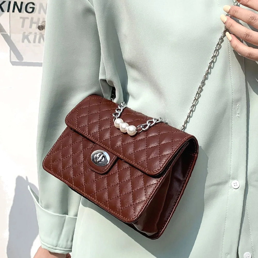 
                      
                        Be elegant with our quilted square bag with flap and twist closure decorated with pearls
                      
                    